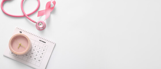 Fototapeta premium Pink ribbon, alarm clock, calendar and stethoscope on light background. Breast cancer awareness concept