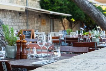 Eingedeckte Tiscche mit Besteck und Weingläsern auf der Terasse eines Restaurants auf der...