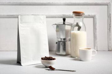 Bag with coffee beans, powder and bottle of milk on white background