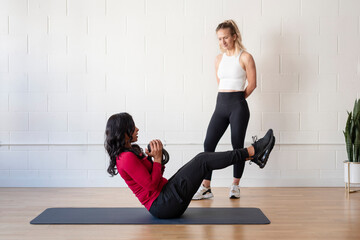 Woman doing kettlebell core workout with trainer support