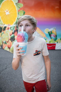 Child eating snowcone at county fair during summer