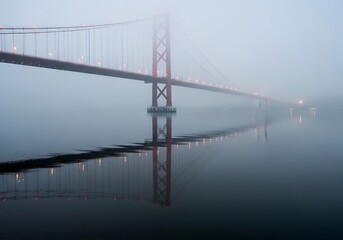 Obraz premium Suspension bridge vanishing into a dense fog, water reflection below
