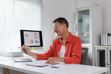 Naklejka premium Mature man analyzing business data in office