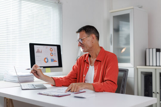 Mature man analyzing business data in office