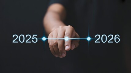 A persons hand touches a line between 2025 and 2026 on a dark background