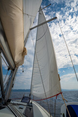 Fototapeta premium Full white sails blown by the wind against blue sky during sailing near Croatia. Symbol of movement, freedom and summer maritime journey.