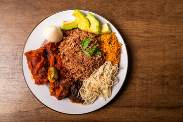 Waakye, Cooked Rice And Beans Served With Tomato Stew, Egg, Gari, Spaghetti, Avocado and Shito, Spicy Pepper Sauce. Africa Ghana Traditional Dish