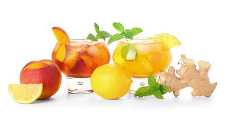 Glasses of cold tea with ginger, mint leaves, peach and lemon slices on white background