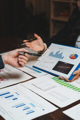 Business professionals discussing financial data charts on documents