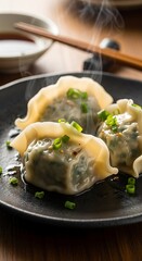 Steaming Hot Dumplings on a Black Plate with Chopsticks.