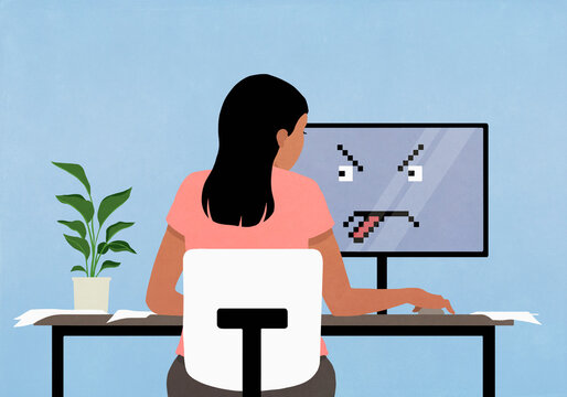 Face on computer screen sticking tongue out at woman working
