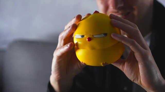A chicken-shaped anti-stress toy.
A soft toy for calming.
A person squeezes a soft silicone toy.