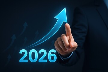 Businessman Pointing at 2026 Growth Arrow with Blue Background for Financial Success, Progress, and Goals