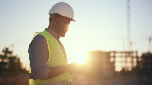 Modern technology for communication and construction innovation, man with phone. Portrait of professional builder, architect, foreman or engineer at construction site, inspired and confident black man