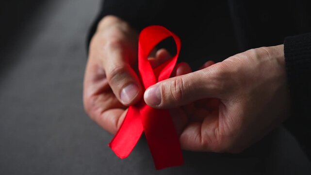 A red ribbon symbolizing solidarity with people living with HIV.
A symbol of HIV infection.
A red ribbon symbolizing support for people living with HIV.