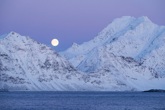 Winter fullmoon rises over snowy mountains, Lofoten Islands, Norway