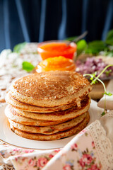 Rustic table setting with pancakes, caviar, sour cream, and onion - cozy homemade winter meal inspired by Nordic tradition.