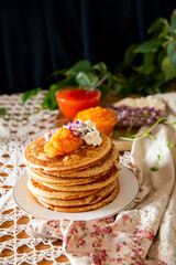 Rustic table setting with pancakes, caviar, sour cream, and onion - cozy homemade winter meal inspired by Nordic tradition.