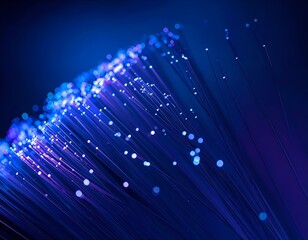 Close-up of glowing fiber optic cables emitting blue and purple light trails