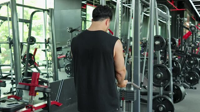 Man Performing Cable Tricep Pushdowns in Modern Gym