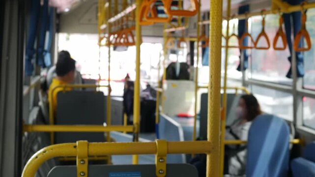 Passengers sitting on public transportation bus or train seats - commuters traveling in urban transit vehicle during daily journey to work.