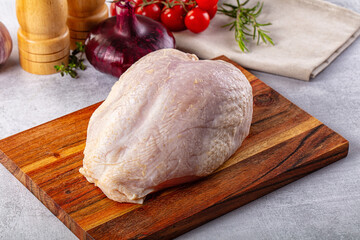 Raw chicken breast with bone and skin
