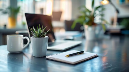 Bright modern office workspace featuring a laptop, coffee mug, notepad with pen, and small potted plant on a sleek desk.