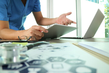 Doctor Using Tablet and Laptop for Online Consultation