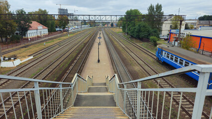 Train station with multiple tracks viewed from staircase in autumn