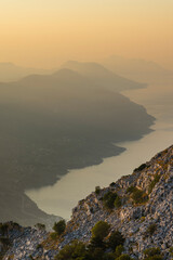 Fototapeta premium Die Bergketten an der Südküste der Halbinsel Pelješac verlieren sich im Dunst bei Sonnenaufgang, Süddalmatien, Kroatien