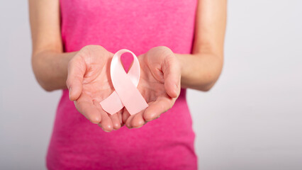 Caucasian female middle aged model shows breast cancer awareness pink ribbon