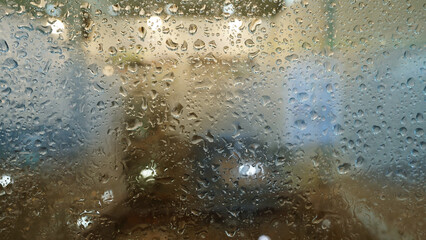 Raindrops on Glass Window with Blurred City View on a Rainy Day