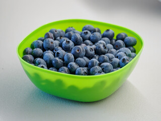 Close-up of Canadian blueberries collected in a green oval bowl.
