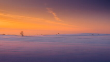 Sunset over vast snowy landscape with calm atmosphere
