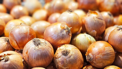 Onion Harvest: A close-up view reveals a bountiful heap of golden onions, their textures and forms...