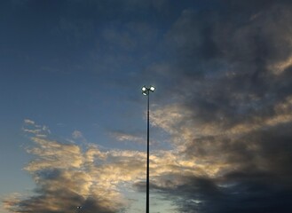 Lamp post on blue sky and cloud in the evening at sunset.