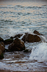Ocean Waves Crashing and Splashing Against Dark Coastal Rocks