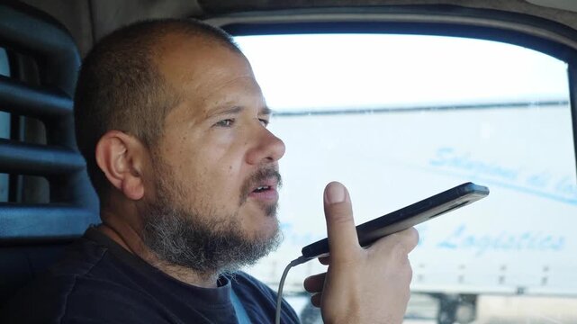 Truck driver talks calmly on the phone while driving on the highway without hands-free devices, ignoring the danger of this risky behavior.