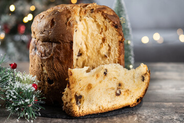 Traditional Italian Panettone on wooden table and christmas tree background