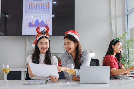 Colleagues celebrating christmas office party analyzing business performance