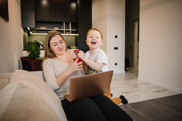 Mother working from home with kid. Quarantine and closed nursery school. Distance learning through war. Child make noise and disturb woman work. Homeschooling and freelance job. Stay at home.