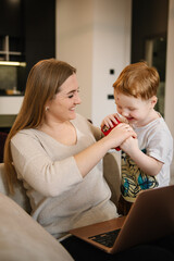 Mother working from home with kid. Quarantine and closed nursery school. Distance learning through war. Child make noise and disturb woman work. Homeschooling and freelance job. Stay at home.