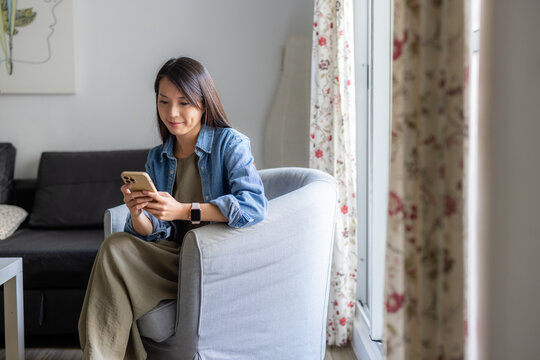 Woman use mobile phone at home indoors