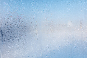 Frozen water drops on glass as an abstract background.