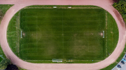 Soccer field surrounded by athletics track - Top down aerial view