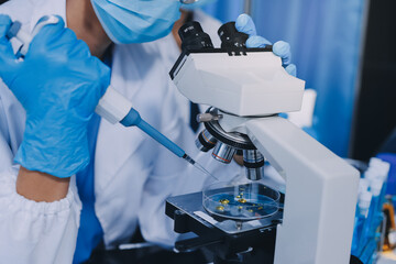 Scientist using microscope in laboratory. Close-up of a researcher's hands adjusting a modern microscope in a lab setting. Science concept