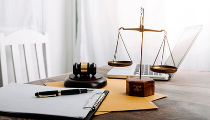 Justice and law concept.Male judge in a courtroom with the gavel, working with, computer and docking keyboard, eyeglasses, on table in morning light