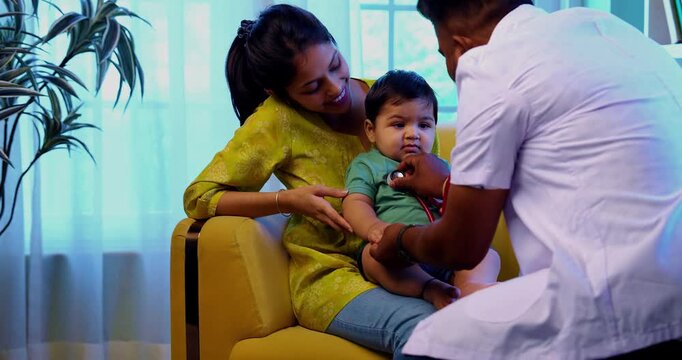 Indian doctor checks infant baby boy with stethoscope while mother holds him in arms during regular health examination in modern clinic, ensuring child wellness, love, care, early health monitoring