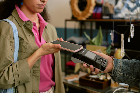 Customer using smartphone for contactless payment in retail store