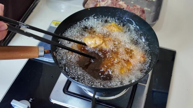 A chef is frying garlic ribs in a pan